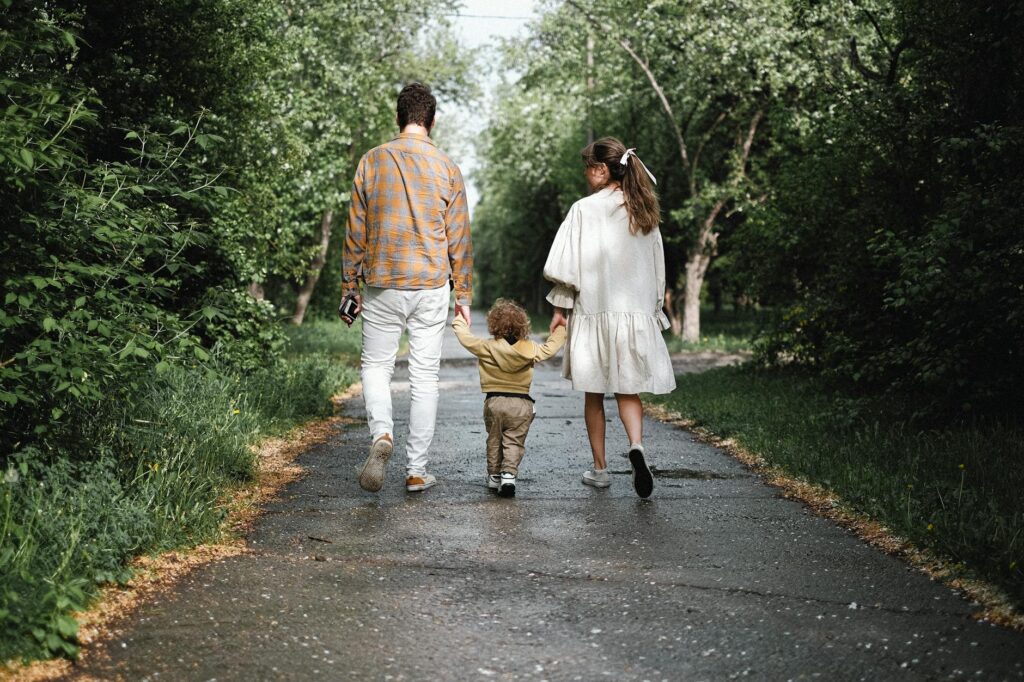a couple and their child walking in the park
