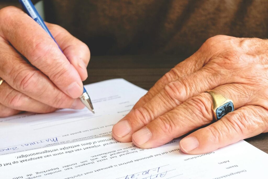 person signing document paper