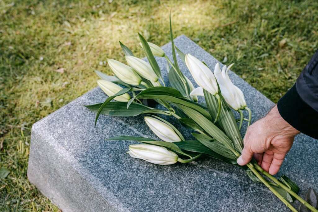 laying flowers over a gravestone